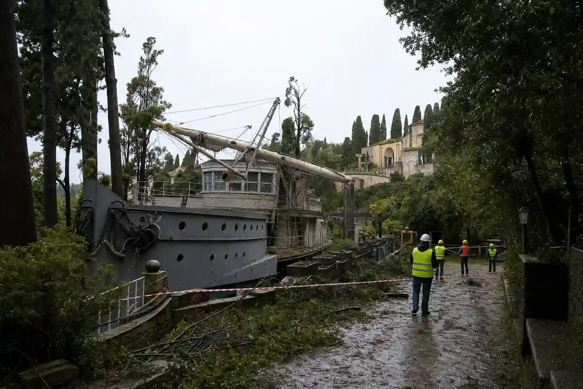 Nave Puglia al Vittoriale con albero maestro crollato e tecnici in giubbotto catarifrangente tra detriti e nastro di